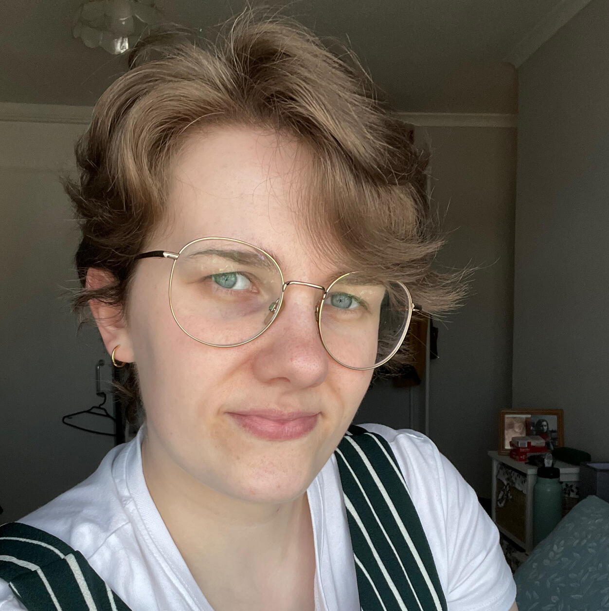 A photograph of me: short brunette hair, wearing glasses, and smiling at the camera.